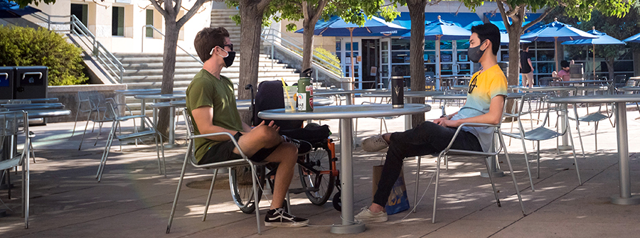 1 of 3, two people sitting at a table in the Price Center